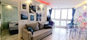 a living room with a couch and pictures on the wall at Luxury ocean view 1 bedroom in Playa de las Americas