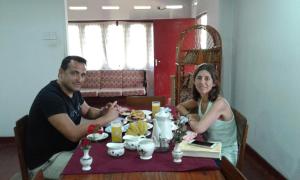 een man en een vrouw zitten aan een tafel bij Surf reef guest house in Mirissa