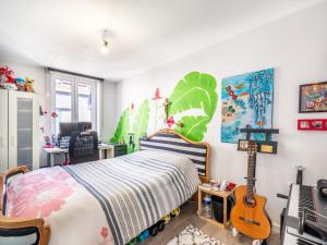 a bedroom with a bed with a guitar in it at Casa Julie in De Panne