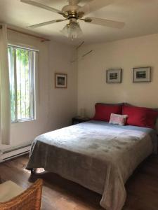 - une chambre avec un grand lit et un ventilateur de plafond dans l'établissement Quiet cozy apartment with A/C, backyard, Netflix, à Montréal
