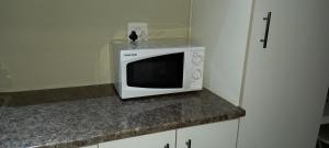 a microwave sitting on top of a counter at DeLutz Overnight Room 3 in Polokwane