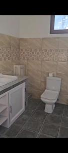 a bathroom with a white toilet and a sink at Villa Benaglia in Mahébourg