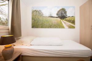 a bedroom with a bed and a painting on the wall at Brunninkhuizerbeek in Hezingen