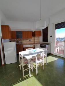 - une cuisine avec une table blanche et des chaises dans l'établissement casa di Baia, à Pesaro