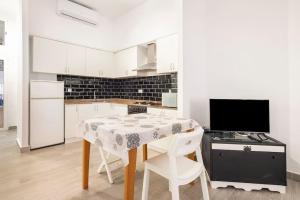 eine weiße Küche mit einem Tisch und einem Herd in der Unterkunft Acogedor alojamiento a pocos metros de la playa in Santa Pola