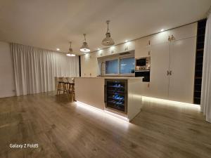 a large kitchen with white cabinets and a table at One of a Kind #PDL Luxury Retreat in Ponta Delgada