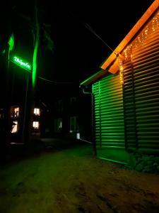 luce verde sul lato di un edificio di notte di Dva Braty eco a Podobovets