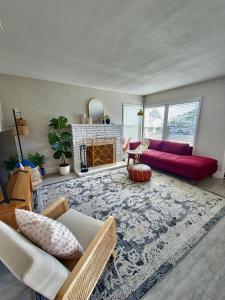 a living room with a red couch and a fireplace at Bungalow Oasis in Concord