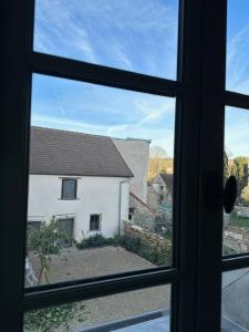 a view from a window of a white house at Jolie grange rénovée. in Couches