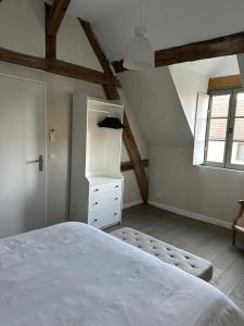Un dormitorio con una gran cama blanca y una ventana en Jolie grange rénovée. en Couches
