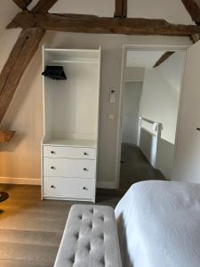 um quarto com uma cama branca e uma cómoda branca em Jolie grange rénovée. em Couches