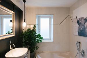 baño con lavabo, bañera y ventana en Cityview Brixen, en Bresanona 43 fotos más