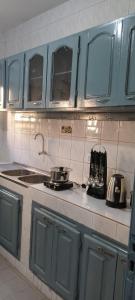 a kitchen with blue cabinets and a counter top at ADISSA in Cotonou