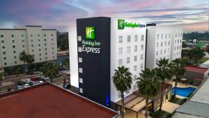 een gebouw met een bord aan de zijkant bij Holiday Inn Express Guadalajara Aeropuerto, an IHG Hotel in Guadalajara