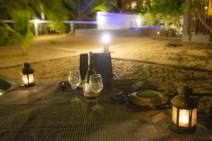 a table with wine glasses and lights on the beach at Blue Ocean Resort in Netolpitiya