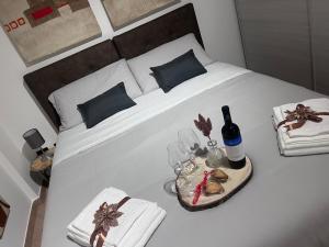 a white bed with a bottle of wine and a tray of food at Theroom41 in Lecce