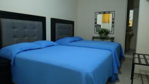 two beds with blue sheets in a bedroom at Hotel Mar Caribe Puerto Vallarta in Puerto Vallarta