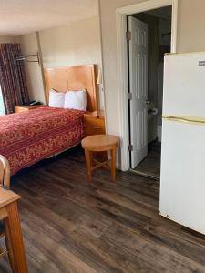 Habitación de hotel con cama y nevera en Wayfarer Motel, en Myrtle Beach