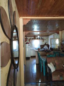 cocina y sala de estar con mesa y espejo en Pousada Avambaé, en São Miguel das Missões