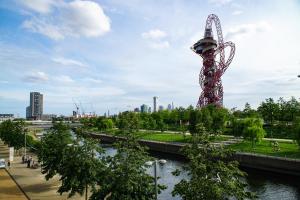 a tall tower in a park next to a river at That Cosy Stay - Fantastic 2 Bed Apartment - Stratford in London