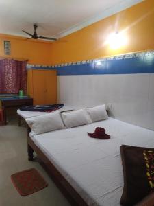 a bedroom with two beds with a red hat on it at PAYEL LODGE in Digha