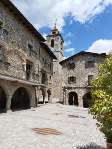 a large stone building with a clock tower at CAL JAN - CADÍ in Bellver de Cerdanya 