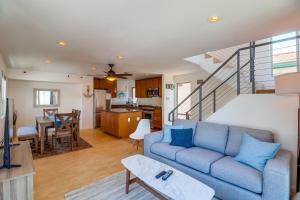 a living room with a blue couch and a kitchen at Beach Oasis - Rooftop, Steps2Sand and Water Views in San Diego