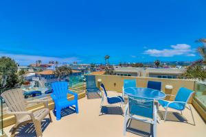 a patio with chairs and a table on a balcony at Beach Oasis - Rooftop, Steps2Sand and Water Views in San Diego