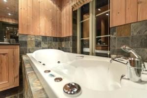 a white bath tub in a kitchen with a sink at Spektakulær hytte med fantastisk utsikt in Strande