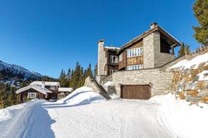 a large stone house with a snow covered driveway at Spektakulær hytte med fantastisk utsikt in Strande