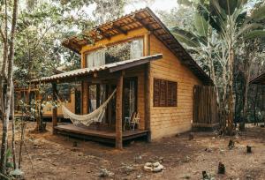 una pequeña casa con una hamaca delante en Chalés Vila Floresta, en Alto Paraíso de Goiás