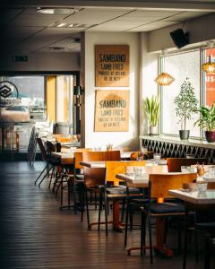 una sala da pranzo con tavoli e sedie in un ristorante di Hildibrand Apartment Hotel a Neskaupstaður