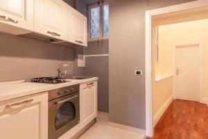 a kitchen with white cabinets and a stove top oven at Monolocale romantico a Napoli in Naples +9 photos