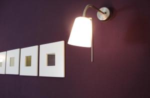 a lamp and a row of books on a wall at Hotel Kamanga in Tomar