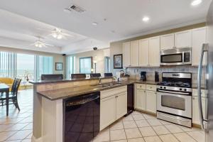 a kitchen with white cabinets and stainless steel appliances at The Wharf in Orange Beach