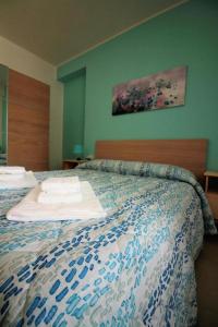 1 dormitorio con 1 cama con toallas en La Rosatea Rooms, en Monreale