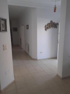 a hallway with white walls and a tiled floor at Villa S+3 Bien Equipée à 200m de la plage in Hammamet