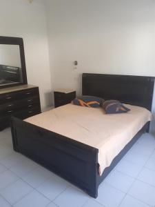 a bedroom with a bed with a dresser and a mirror at Villa S+3 Bien Equipée à 200m de la plage in Hammamet