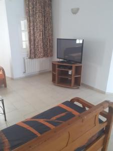 a living room with a flat screen tv and a couch at Villa S+3 Bien Equipée à 200m de la plage in Hammamet