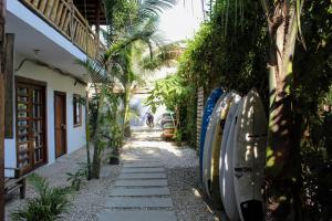 a walkway in front of a house with palm trees at Aloha.ayampe in Ayampe