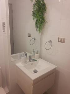 een witte badkamer met een wastafel en een spiegel bij Central Vip Antofagasta in Antofagasta