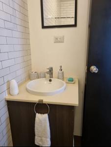 y baño con lavabo blanco y espejo. en Apartamento tipo Loft, en Guatemala