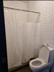baño con aseo y cortina de ducha blanca en Apartamento tipo Loft, en Guatemala