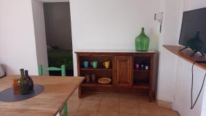 Habitación con mesa, TV y estante. en La Carmela en San Rafael