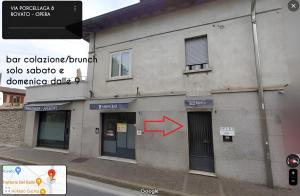 a building with a red arrow on the side of it at Foresteria Opera in Rovato