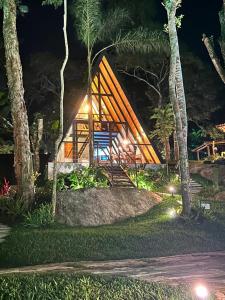 a small tree house in the woods at night at Chalés das Palmeiras in Itaipava