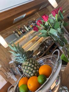 a bowl of fruit with a pineapple and a vase of flowers at Landhotel Alte Post in Oberstaufen