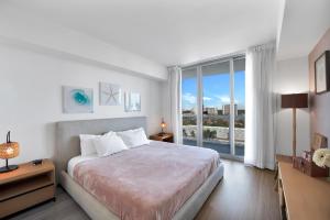 a bedroom with a large bed and a large window at Water View Building With Pool - 5-Min Walk To The Beach in Hallandale Beach