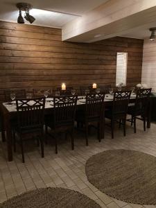 Hotelli Olla في Somero: غرفة طعام مع طاولة وكراسي خشبية طويلة