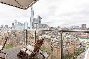 a balcony with two chairs and a view of the city at Stunning London View Flat in London